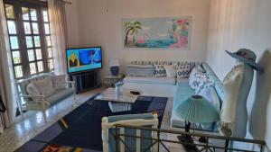 a living room with a couch and a tv at Βίλα Πασιθέα in Khánia