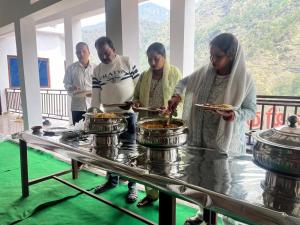 a group of men preparing food on a table at Kedar Mount View in Sonprayag