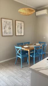 a dining room with a table and blue chairs at Respiro Di Mare in Torre del Greco +29 photos
