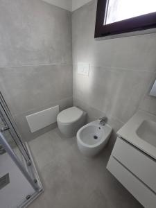 a white bathroom with a toilet and a sink at Casa Giulia in Stintino +8 photos