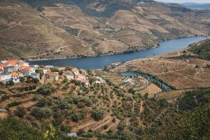 an aerial view of a village on a hill next to a river at Panorama Douro House in Armamar