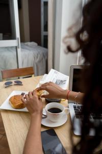 a woman sitting at a table eating a sandwich and a cup of coffee at Le felix in Antananarivo