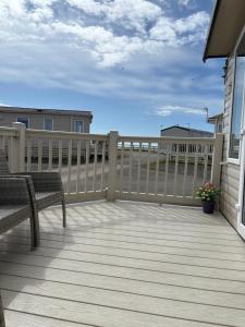 a deck with two chairs and a fence at Bobby's Bolthole in Heysham