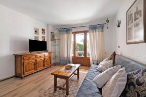 a living room with a couch and a tv at Casa Abril in L'Ampolla