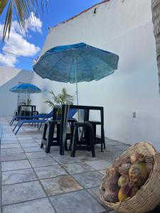 a table with a blue umbrella and a basket of fruit at É de casa unidade 01- JUAZEIRO DO NORTE in Juazeiro do Norte