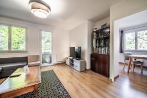 a living room with a couch and a tv at Appartement Cosy Parc Thermal in Thonon-les-Bains