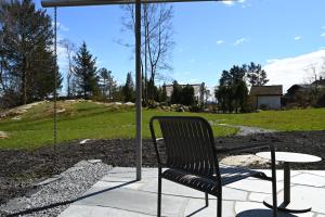 a chair sitting under an umbrella next to a table at Østhusvik Cabin in Stavanger