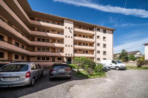 a building with cars parked in a parking lot at Appartement Cosy Parc Thermal in Thonon-les-Bains