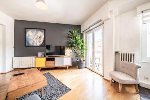 a living room with a tv and a couch and a table at Appartement Proche Lac et Thermes in Thonon-les-Bains
