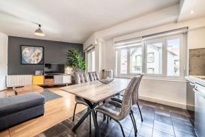 a living room with a wooden table and chairs at Appartement Proche Lac et Thermes in Thonon-les-Bains
