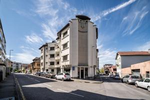 a tall building on a city street with cars parked at Appartement Proche Lac et Thermes in Thonon-les-Bains