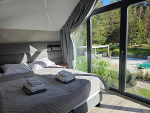 a bedroom with a bed with two towels on it at NOVA ULINIA Sea - dom nad morzem, podgrzewany basen, sauna, balia z jacuzzi,Starlink in Ulinia +51 photos