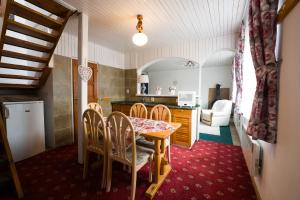 a kitchen and dining room with a table and chairs at Drevenička U Ježka in Ždiar