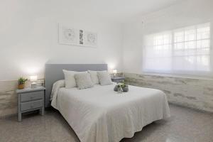 a bedroom with a large white bed with flowers on it at Apartament Cristina in Deltebre