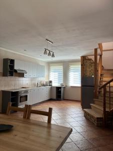 a large kitchen with white cabinets and a staircase at Vaivari Retreat in Jūrmala