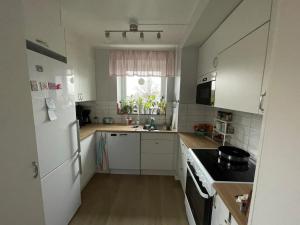 a kitchen with white cabinets and a white refrigerator at Morfslottet in Gothenburg