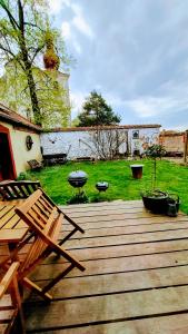 a wooden deck with two chairs and a table at Petrův dům u mlýna in Slup