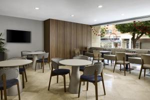a restaurant with tables and chairs and a tv at iStay by NH Ciudad de Valencia Hotel in Valencia