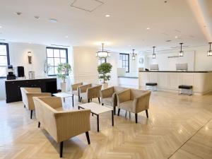 a room with chairs and tables and a kitchen at THE DAY HOTEL ShinYokohama in Yokohama