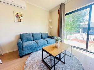 a living room with a blue couch and a table at Modern Comfy 3 Bedrooms House in Chartwell in Hamilton