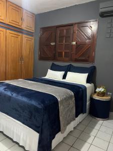 a bedroom with a large blue bed with wooden cabinets at É de casa unidade 01- JUAZEIRO DO NORTE in Juazeiro do Norte