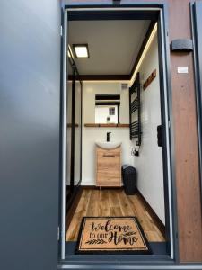 a door with a sign that reads welcome to our tiny house at Glamping Hive in Čmeliny +75 photos
