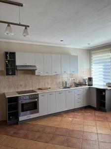 a large kitchen with white cabinets and appliances at Vaivari Retreat in Jūrmala