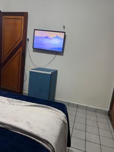 a bedroom with a bed and a tv on the wall at É de casa unidade 01- JUAZEIRO DO NORTE in Juazeiro do Norte