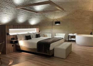 a bedroom with a large bed and a bath tub at Hotel Maria Cristina in Toledo +59 photos