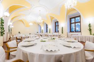a large banquet hall with white tables and chairs at Nové Adalbertinum in Hradec Králové