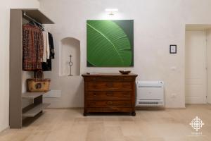 a room with a dresser and a green painting on the wall at Casa Philomena - Fascino storico in centro in Noto +56 photos