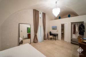 a bedroom with a mirror and a desk in a room at Casa Philomena - Fascino storico in centro in Noto