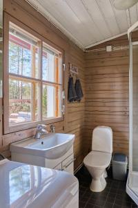 a bathroom with a toilet and a sink at Holiday Cabin Kukkula - AC, fireplace & wood-fired sauna in Porvoo +23 photos