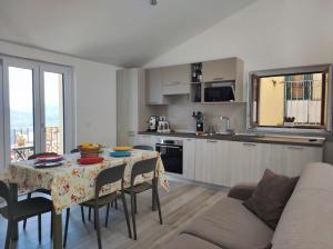 a kitchen and living room with a table and a couch at Casa Zia Maria in Pollina