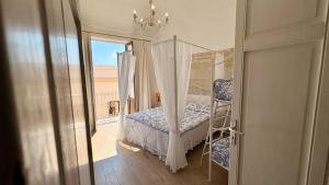 a bedroom with a canopy bed and a balcony at Al centro con panorama Favignana Isole Egadi in Favignana