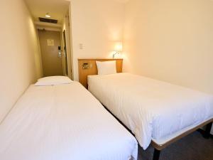 two beds in a room with white sheets at THE DAY HOTEL ShinYokohama in Yokohama +71 photos