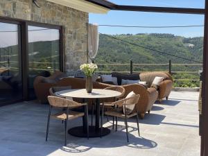 a patio with a table and chairs with a view at Bubo House in Črni Kal