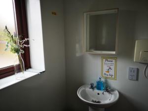 a bathroom with a sink and a mirror and a window at The Gather - Tarbert Argyll in Tarbert