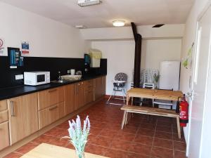 a kitchen with wooden cabinets and a table in it at The Gather - Tarbert Argyll in Tarbert