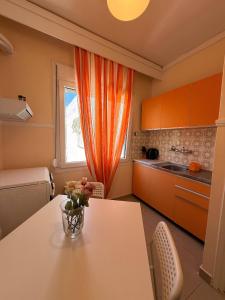 a kitchen with an orange curtain and a table at Helios in Kavála