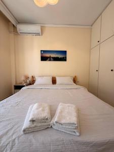 a bedroom with a white bed with two towels on it at Helios in Kavála