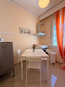 a kitchen with a white table and chairs at Helios in Kavála