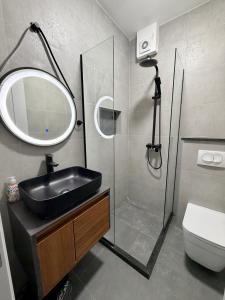 a bathroom with a sink and a shower with a mirror at Apartments Regata in Ulcinj