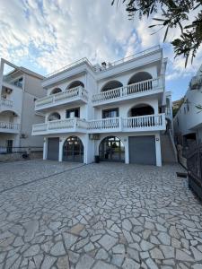 a large white building with a large driveway at Apartments Regata in Ulcinj