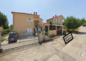 a sign in front of a house with a driveway at Suitable Summer Apartments in Pula