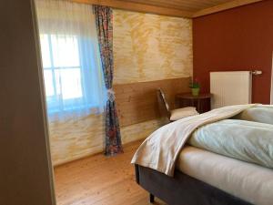 a bedroom with a large bed and a window at Sissy Appartment in Kössen +7 photos