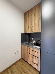 a kitchen with wooden cabinets and a refrigerator at Apartments Regata in Ulcinj