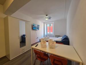 a room with a table and chairs and a bed at Arlecchino - By Turent in Pietra Ligure