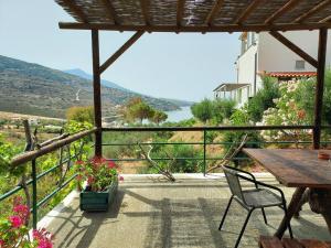 a patio with a table and chairs and a view at Stone Kypri Apartment Andros in Kipri