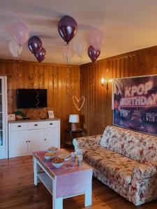 a living room with balloons and a couch and a table at Kuća za odmor Srce in Slavetić